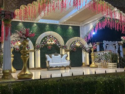 Wedding stage with white sofa, floral arches and green wall, Dharam Vatika Sohna Gurgaon