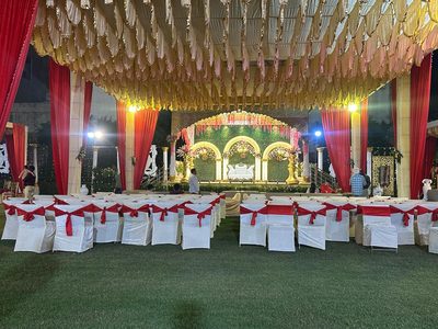 Guest seating with red-ribbon chair covers facing the stage at Dharam Vatika, Sohna Gurgaon
