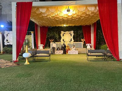 Lawn lounge seating under a draped pavilion at Dharam Vatika party lawn, Sohna Gurgaon